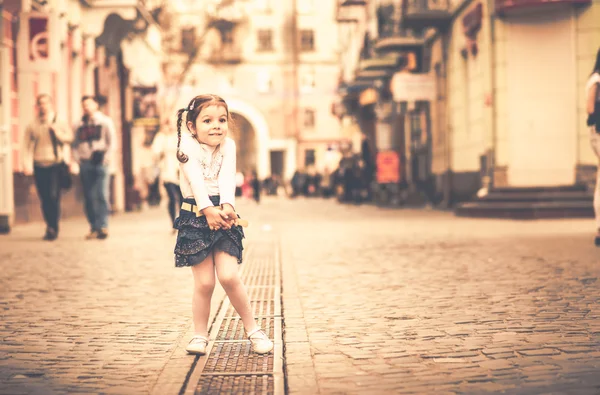 Piccola bella ragazza che cammina sulla strada della città — Foto Stock