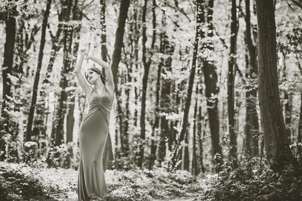 Kobieta w sukni długie spacery w lesie, efekt ziarna — Zdjęcie stockowe