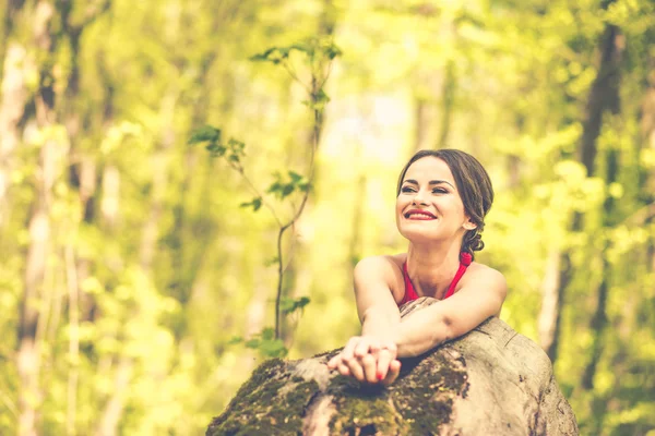 Donna in abito rosso lungo a piedi nella foresta — Foto Stock