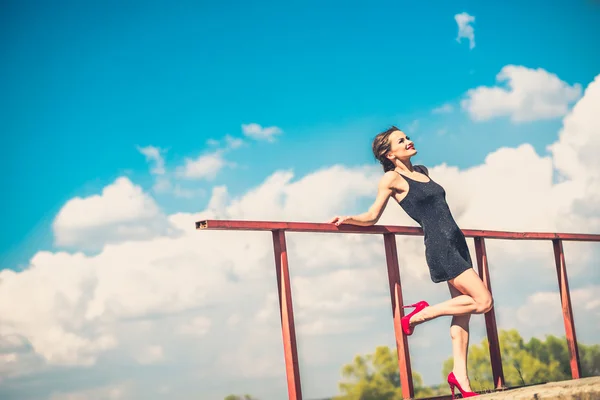 Bella donna in breve abito nero sul ponte — Foto Stock