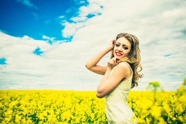 En vacker flicka vandrar i fältet — Stockfoto