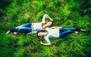 Kızlar yeşil çim üzerinde yalan