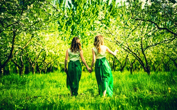 Girls walking on the apple trees garden — Stock Photo, Image