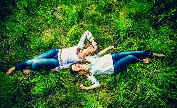 Meisjes liggend op het groene gras — Stockfoto