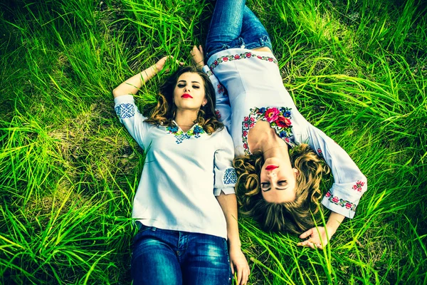 Meninas deitadas na grama verde — Fotografia de Stock