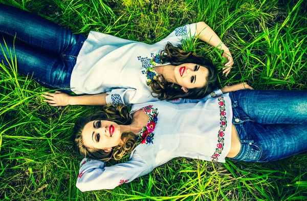 Girls lying on the green grass — Stock Photo, Image