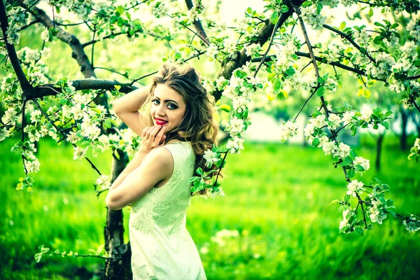 Kvinna i trädgården under blossom träd — Stockfoto