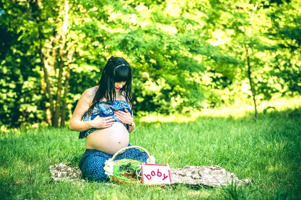 Беременная женщина расслабляется на открытом воздухе — стоковое фото