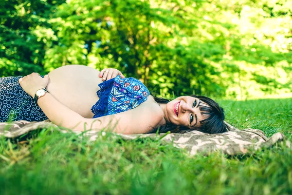 Беременная женщина расслабляется на открытом воздухе — стоковое фото