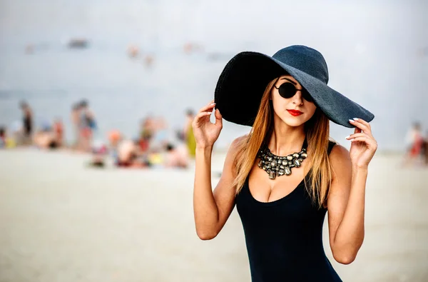 Mladá krásná žena na pláži v černé plavky — Stock fotografie