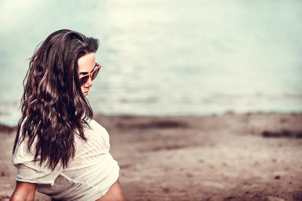 Långa hår flicka avkopplande på stranden — Stockfoto