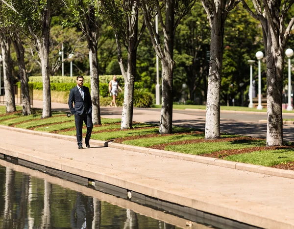 Businessman walking in park — Stock Photo, Image
