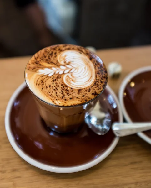 Tasse Cappuccino-Kaffee mit dekorativem Blattmuster — Stockfoto