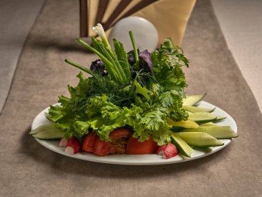 Taze salatalık, domates, turp ve bitkilerle sebze dilimleri.