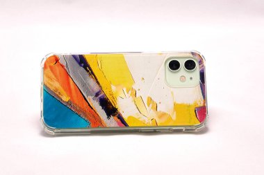 Açık arkaplan üzerinde çok renkli bir çantada modern akıllı telefon