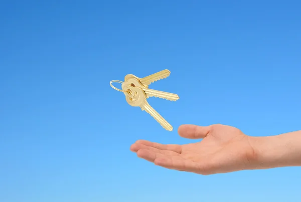 Keys in hand over sky background. — Stock Photo, Image
