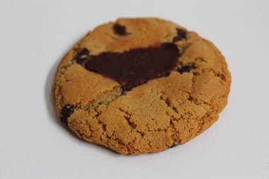 Bir çikolatalı kurabiye, erimiş çikolata, beyaz arka planda izole edilmiş.