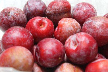 Beyaz arka planda izole edilmiş taze kırmızı erik yığını.