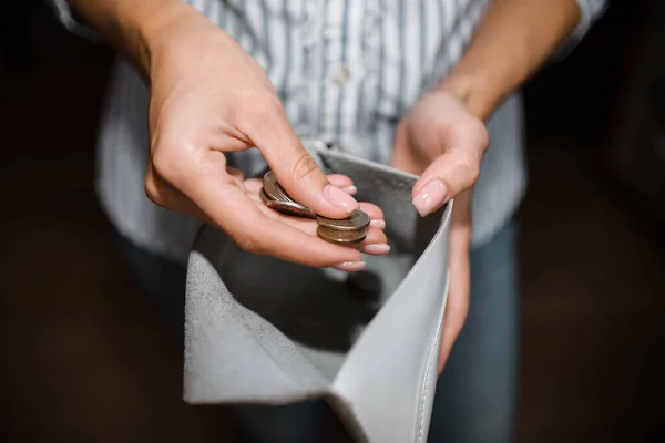 Woman counts money, a close-up of a purse with ruble coins. The concept of bankruptcy, income decline, job loss. Selective focus, dark background