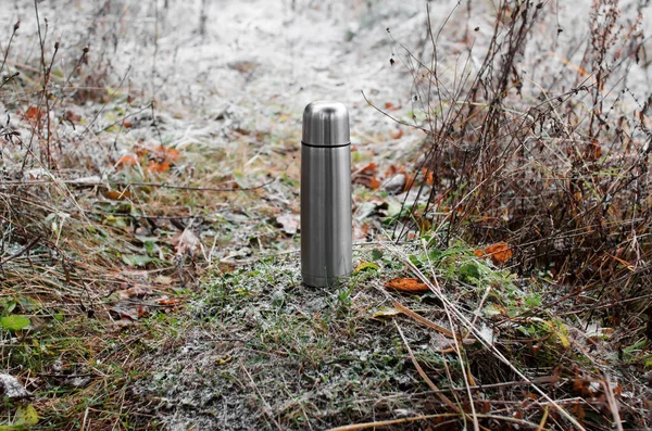 冬の森の中の草の上に立つアルミニウム製の魔法瓶 コンセプトハイキング — ストック写真