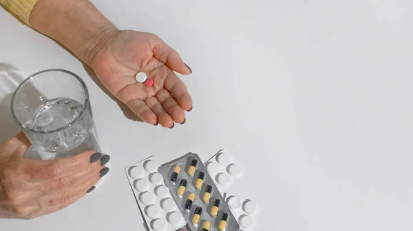 薬を飲んでいる高齢女性 女性の手を閉じ 水や錠剤のガラスを保持し 白い背景のコピースペース 治療の概念 病気の退職 — ストック写真