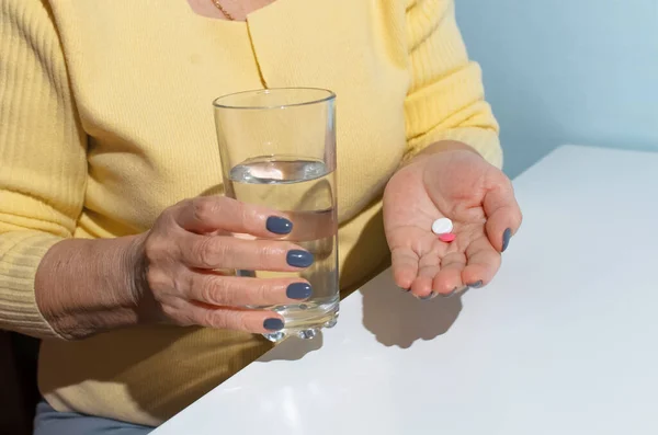 高齢女性は錠剤を飲む 水と薬のガラスを保持する女性の手のクローズアップ 治療の概念 病気の退職 — ストック写真
