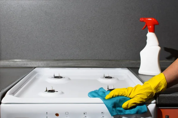 手袋の女性の手ガスストーブ クローズアップのパネルを拭く 女性の洗濯キッチンアパート コピースペース — ストック写真