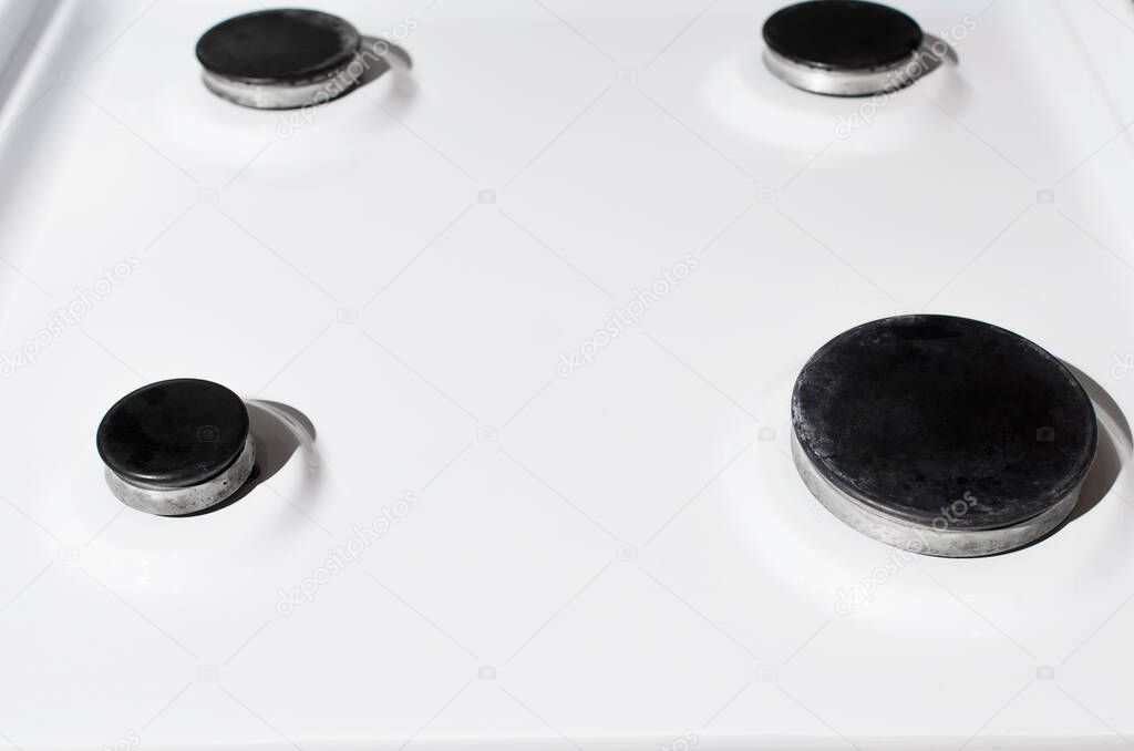 Clean white surface of the gas stove. Hotplate close-up, selective focus. Gas panel after cleaning