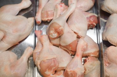 Dükkandaki vitrinde çiğ tavuk bacağı, yakın plan. Seçici yumuşak odak