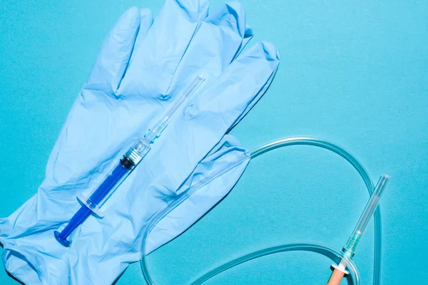 Medische Apparatuur Close Spuit Handschoenen Druppelaar Een Blauwe Achtergrond Plat — Stockfoto