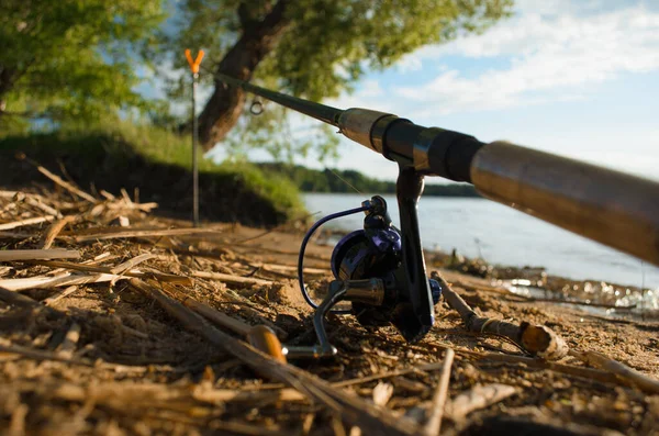 湖の岸に釣竿 回転リールのクローズアップ 選択的フォーカス 釣りの概念 — ストック写真