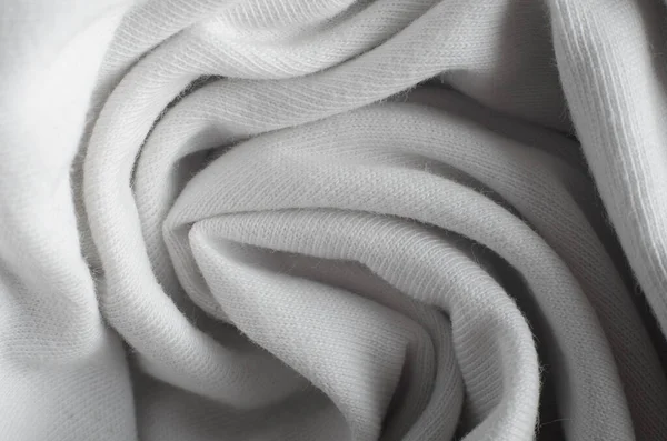 Close-up of white rolled cloth, macro photo. Textile fleecy texture background, top view.