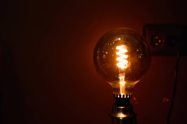 Klasik yuvarlak lamba, kapalı alanda parlayan retro ampul. Lambaya seçici odaklanma