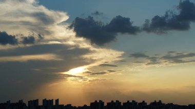 Yuvarlak güneşli güzel gün batımı manzarası ve gökyüzündeki renkli bulutlar.