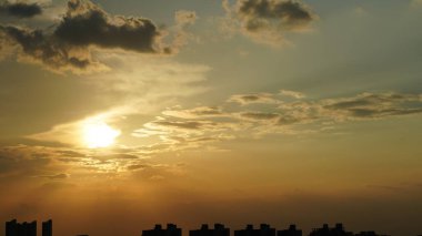 Yuvarlak güneşli güzel gün batımı manzarası ve gökyüzündeki renkli bulutlar.