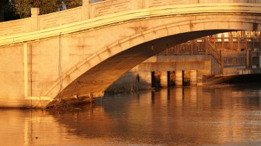 Güzel eski Çin kasabasının günbatımı manzarası. Arka planda taş kemerli köprü var.