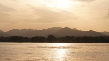 Güzel gün batımı manzarası, kışın gölün yanındaki suyun yansıması.