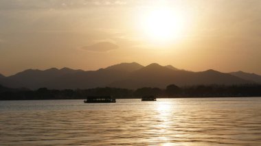 Güzel gün batımı manzarası, kışın gölün yanındaki suyun yansıması.