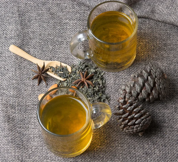 Green tea with the pine cones on the table — Stock Photo, Image
