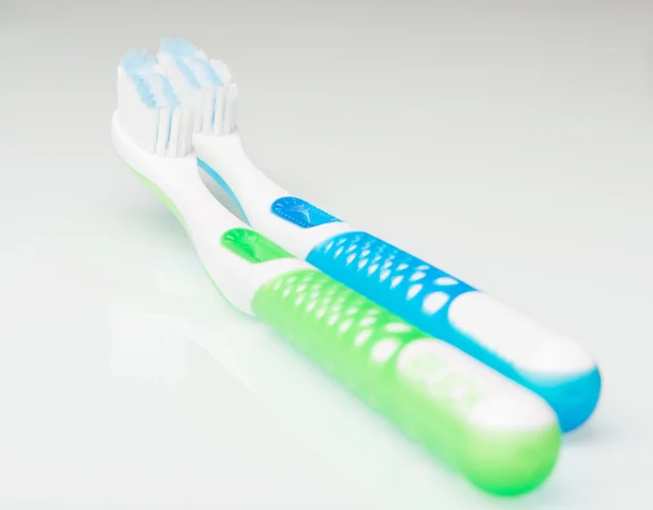 Toothbrushes on a glass table — Stock Photo, Image