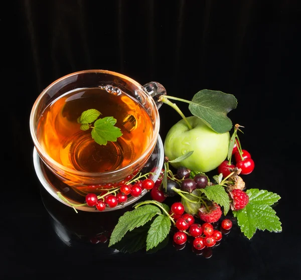 Berry cuts and hot tea on black background — Stock Photo, Image