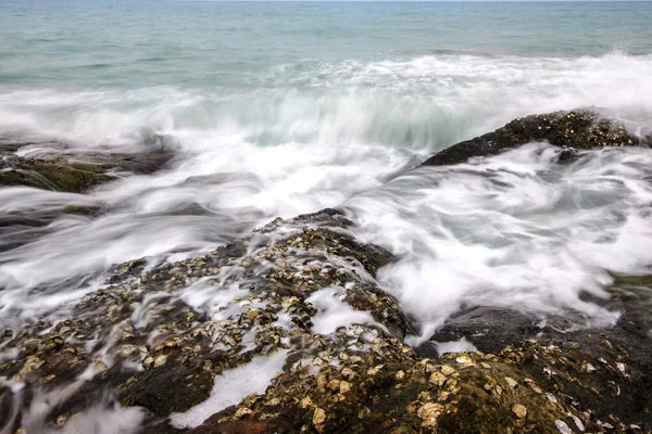 Vagues de mer s'écrasant sur les roches créant de la mousse — Photo