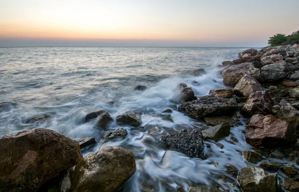 Belo pôr do sol na praia com ondas batendo — Fotografia de Stock