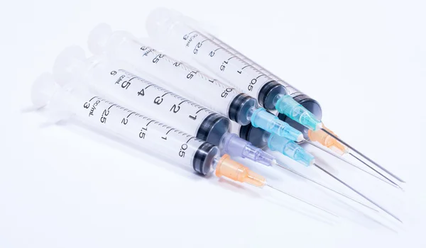 Syringe met druppel en geneeskunde op witte achtergrond. — Stockfoto