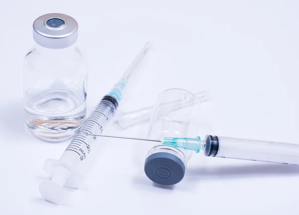 Syringe met druppel en geneeskunde op witte achtergrond. — Stockfoto
