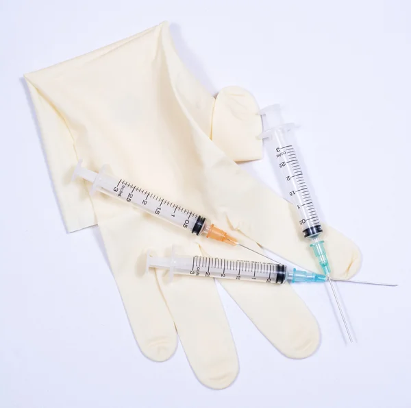 Surgical glove, mask, cap and syringe on white background. — Stock Photo, Image