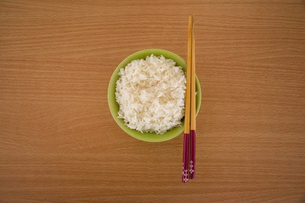 Rice in a bowl and wooden chopsticks. — Stock Photo, Image