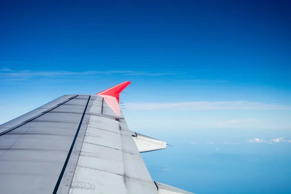Pohled oknem letadla během letu v křídle s krásnou modrou oblohou. — Stock fotografie