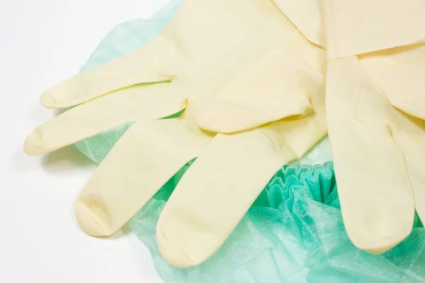 Chirurgiczne lateksowe rękawiczki i czapka na białym tle. — Zdjęcie stockowe