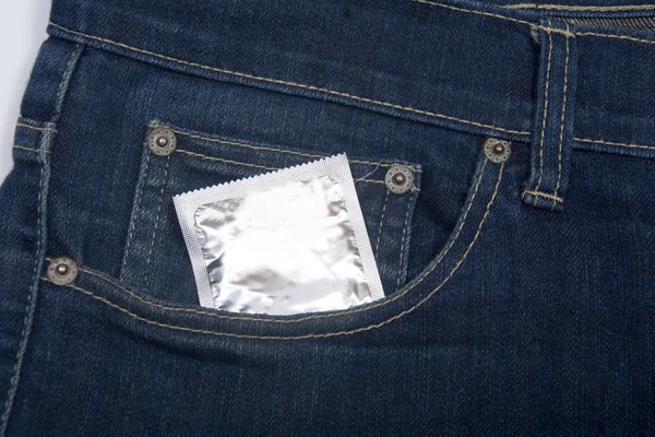 Кондом у джинсовій кишені. Текстура, фон . — стокове фото